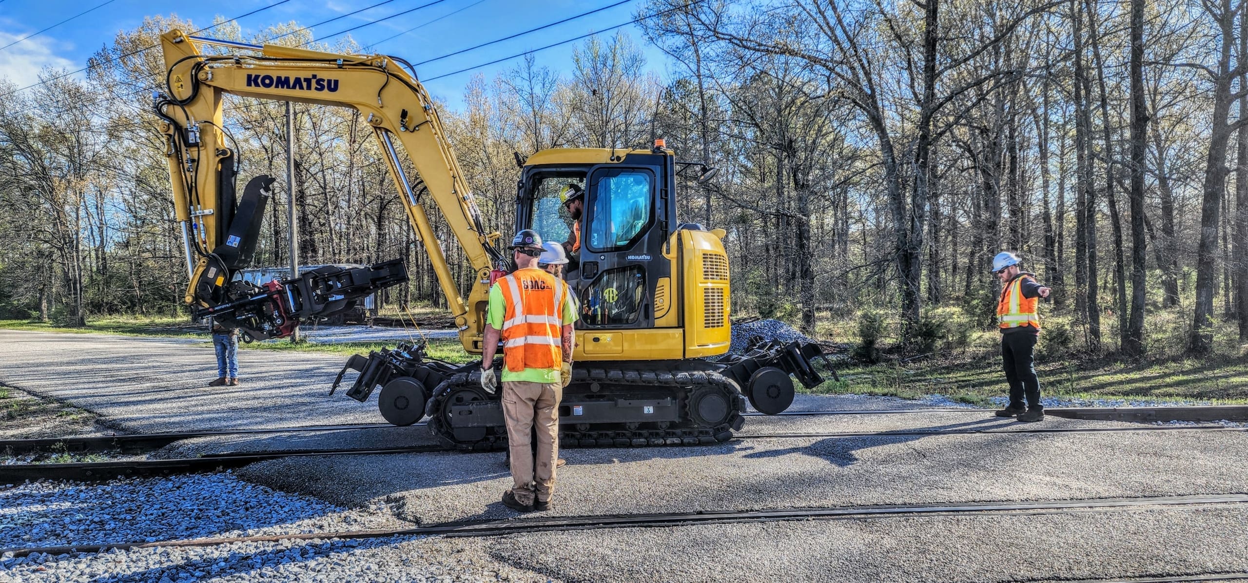 Hi-rail excavator attachment guiding an excavator along the rails during on-track orientation in Alabama.