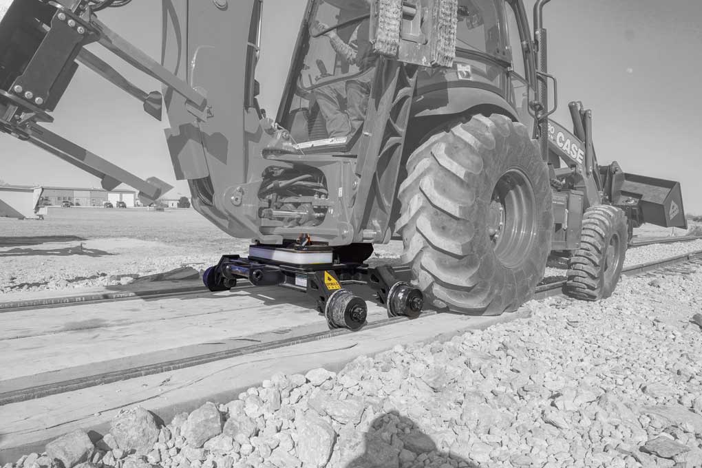 Case backhoe with Rail Rider hi-rail system Case backhoe loader equipped with the Dymax Rail Rider hi-rail guide system on rail