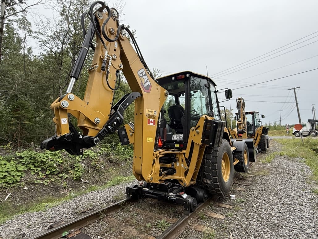Caterpillar hi-rail backhoe using Dymax LoPro Rail Rider equipment on CN railroad track