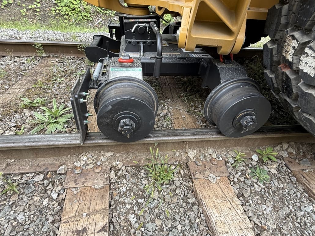 Close-up of rear LoPro rail wheels mounted under a backhoe on track