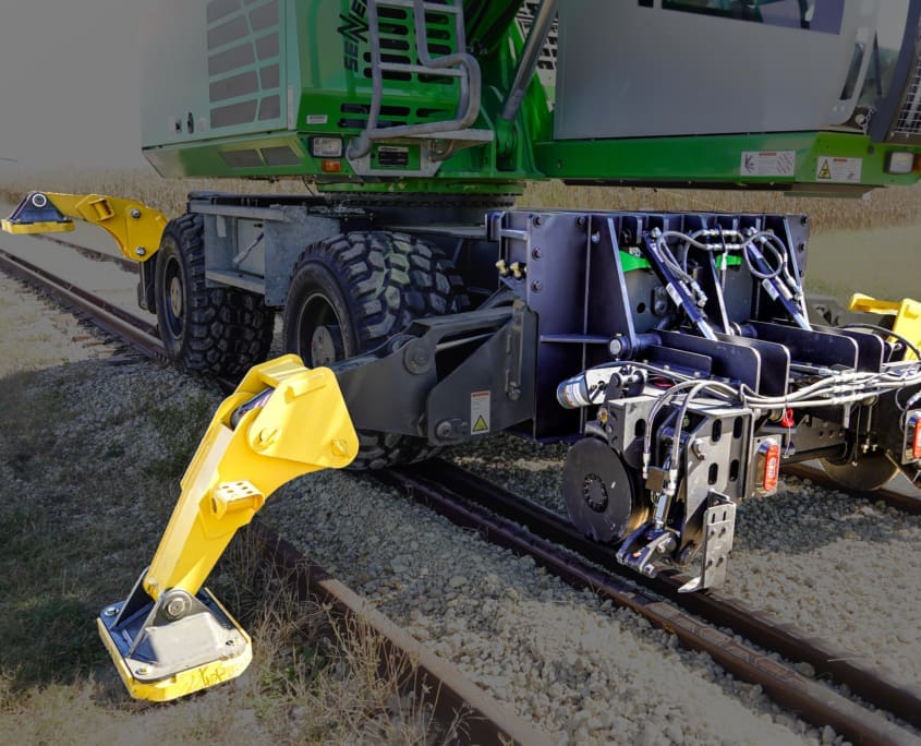 WX4S — wheel excavator with 4 stabilizers working on rail tracks DymaxRail Rail Rider WX4S hi-rail system on wheel excavator with all four stabilizers extended on rail